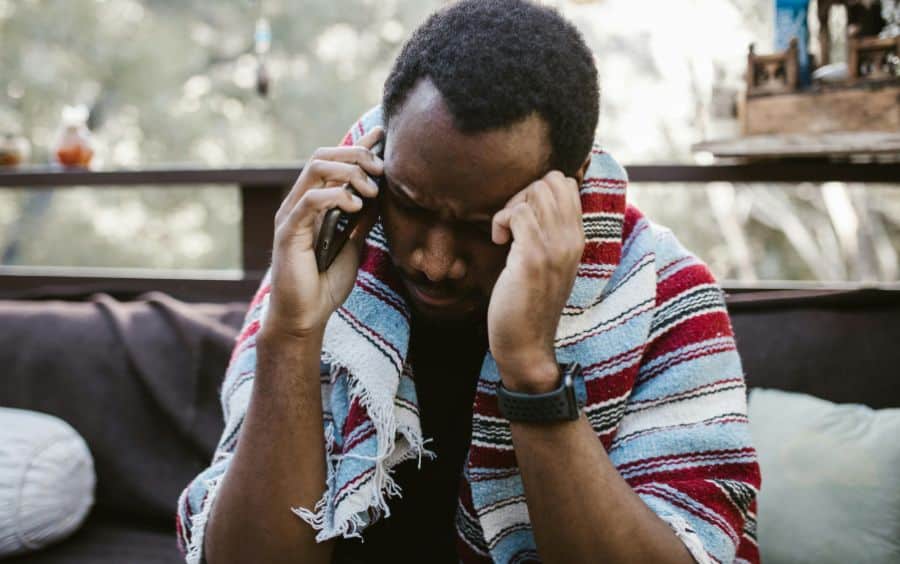 Homem com problemas com o jogo tomando o primeiro passo e ligando para buscar ajuda profissional e gratuita.