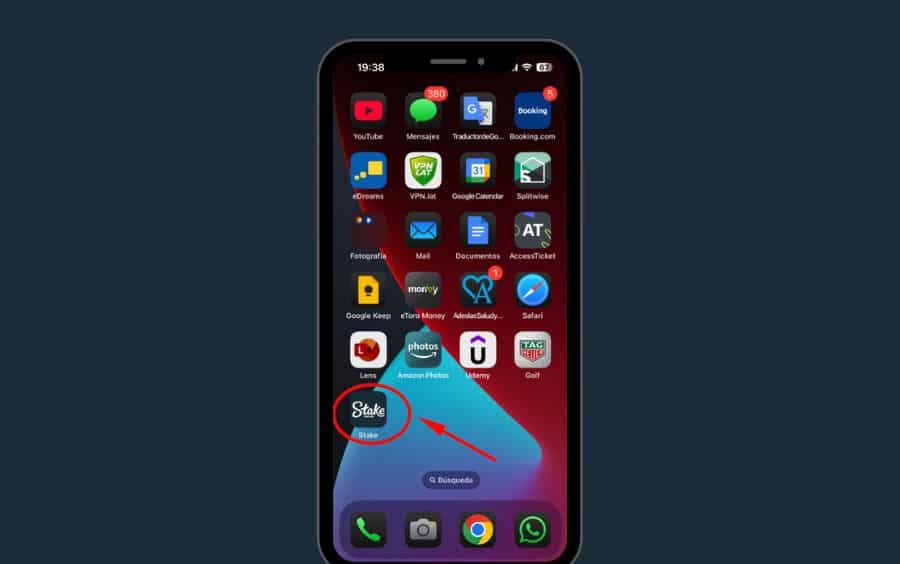 Passo 5 do tutorial de atalho da Stake no iOS, mostrando a tela inicial de um iPhone com uma seta vermelha apontando para o ícone "Stake" recém-criado.
