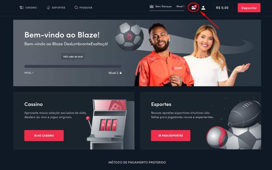 Passo 1 do tutorial 'Indique um Amigo' da Blaze, mostrando a página inicial logada com uma seta apontando para o ícone da 'caixa de mensagens' (envelope) no menu superior, onde a promoção é encontrada.