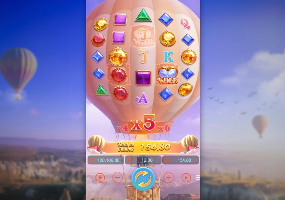 Tela de jogo do slot Skylight Wonders com balão de ar quente, símbolos de gemas e letras, símbolo Wild e multiplicador x5 em destaque.