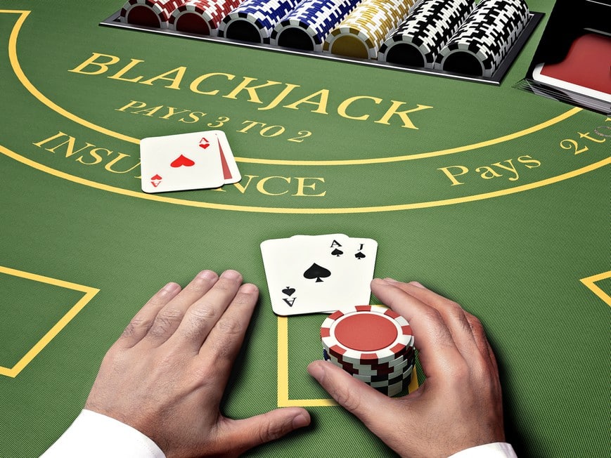 Jogador em mesa de blackjack com cartas, fichas e vários baralhos na sapata.